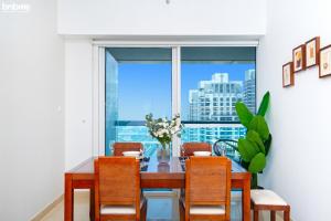 a dining room with a table and chairs and a window at bnbmehomes - Live & Work 'w' Style in 1B Apt - 3007 in Dubai