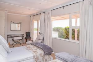 a bedroom with a bed and a large window at Fairhill Farm in Gansbaai