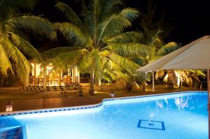 a swimming pool with a umbrella and palm trees at Villa Anakao Mauritius in Port Louis