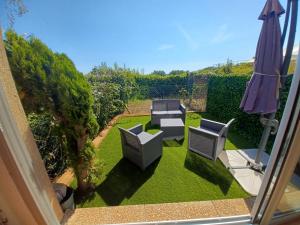 an aerial view of a garden with chairs and an umbrella at L'Eau-Dyssée, clim, parking privé, jardin in Saint-Laurent-du-Var