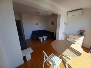 sala de estar con mesa, sillas y sofá en L'Eau-Dyssée, clim, parking privé, jardin, en Saint-Laurent-du-Var