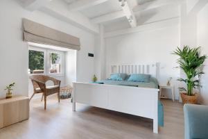 a white bedroom with a bed and a chair at Casa Sol 21 B Garachico in Garachico