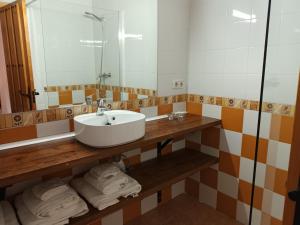 a bathroom with a sink and a mirror and towels at Casas rurales La Trufa Madre Casa 3 in Vega del Codorno +28 photos