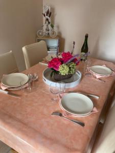 una mesa con platos y vasos y un jarrón de flores en au fer à Cheval, en Cresseveuille