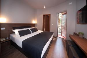 a bedroom with a large bed and a television at Hotel Carla in Levanto