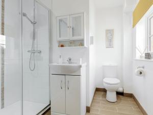 a white bathroom with a sink and a toilet at Olde Oak Cottage in Stourton
