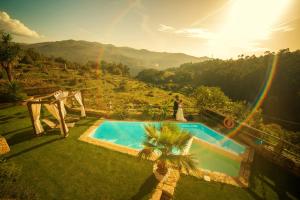 a bride and groom standing next to a pool with a rainbow at Casa Favo de Mel - Jacuzzi Privado in Arcos de Valdevez