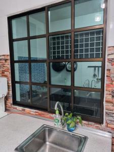 un fregadero frente a una gran ventana en PRIVATE POOL Ssue Klebang Ipoh Homestay-Guesthouse With Wifi & Netflix, en Chemor