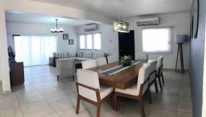una sala da pranzo e un soggiorno con tavolo e sedie. di House In Miramar Seaview And Private Pool templada a Guaymas