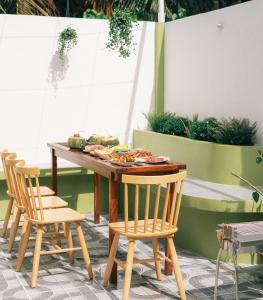 una mesa con sillas y comida en el patio en Phòng Mơ - Nhà Mơ Homestay Bến Tre, en Ben Tre