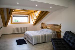 ein Schlafzimmer mit einem Bett, einem Sofa und einem Fenster in der Unterkunft BED&BREAKFAST TABINE in San Giacomo