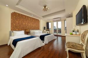 a hotel room with two beds and a flat screen tv at Hanoi Delica Hotel in Hanoi