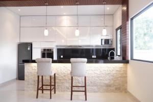 a kitchen with a black and white counter and white appliances at Villa Niang Ando in Labuan Bajo