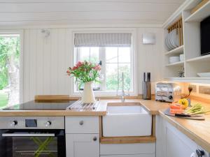 una cocina con fregadero y un jarrón de flores en Under Willows - Uk12608 en Burton Overy