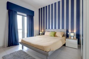 um quarto com uma cama com riscas azuis e brancas em Seaview Apartment Top Location in Sliema em Sliema