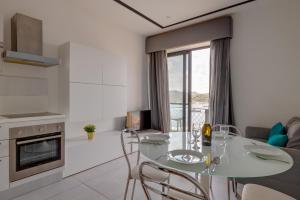 een keuken en een woonkamer met een glazen tafel en stoelen bij Seaview Apartment Top Location in Sliema in Sliema