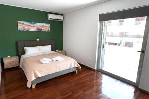 - une chambre avec un lit et un mur vert dans l'établissement Sea view apartment in Alimos region (D4), à Athènes