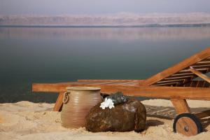 a vase and a rock on the beach next to a bench at Holiday Inn Resort Dead Sea, an IHG Hotel in Sowayma