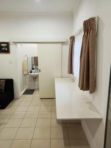 ein Bad mit einer weißen Theke in einem Zimmer in der Unterkunft Danodeb Lodge in Pietermaritzburg