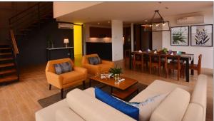 プエルト・プリンセサにあるSodi's Penthouse 401のリビングルーム(ソファ、椅子付)、キッチンが備わります。