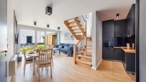 a kitchen and a living room with a table and a staircase at CALVO Łeba, Nowecin in Łeba