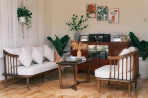a living room with a couch and a table at Phòng Dừa - Nhà Mơ Homestay Bến Tre in Ben Tre