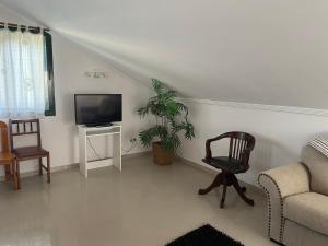 a living room with a chair and a television at A CASA DE SISAN in Ribadumia