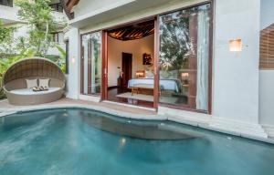 a swimming pool in a villa with a bedroom at Tanadewa Resort Ubud Bali by Cross Collection in Ubud
