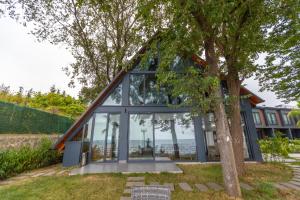 a house with glass windows and a tree at SANTANA OTEL in Trabzon
