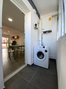 a washing machine in a room with a table at Apartamento vacacional in Redondela