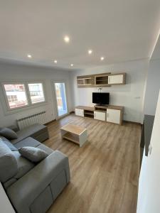 a living room with a couch and a tv at Apartamento vacacional in Redondela