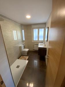 a bathroom with a shower and a toilet and a sink at Apartamento vacacional in Redondela