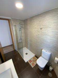 a bathroom with a white toilet and a shower at Apartamento vacacional in Redondela
