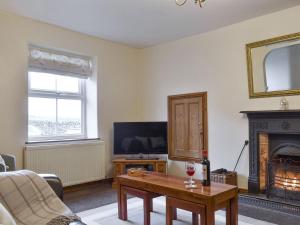 a living room with a coffee table and a fireplace at Slaters Cottage in Middleham