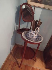 a table with a mirror and a tea pot on a stool at El Desván del Campanero in Murillo de Gállego