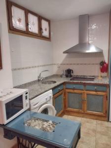 a kitchen with a sink and a stove top oven at El Desván del Campanero in Murillo de Gállego