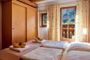 1 dormitorio con 2 camas, toallas y ventana en Apartment Linde- Fiechterhof, en Sarentino