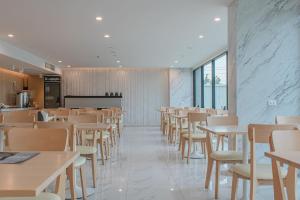 ONE Hotel في محافظة باثوم ثاني: غرفة طعام مع طاولات وكراسي بيضاء