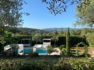 une villa avec une piscine dans un jardin dans l'établissement Mas Saint Antoine, à Grasse