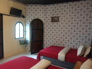 1 dormitorio con cama roja y ventana en Tube Bromo Homestay en Probolinggo