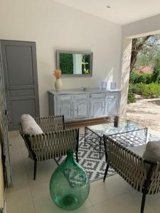 - un salon avec un vase, 2 chaises et une table dans l'établissement Mas Saint Antoine, à Grasse