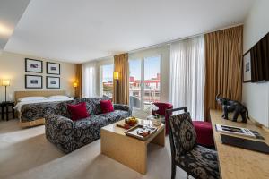日内瓦碧玉玛诺特酒店的带沙发的客厅和带沙发床的房间