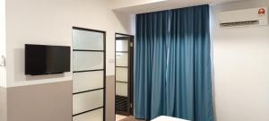 um quarto com um espelho e uma cortina azul em Roxy Hotel Sri Aman em Simanggang