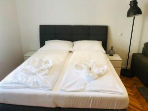 - un lit avec des serviettes blanches dans l'établissement Fewo Kuferzeile Gmunden seenähe, à Gmunden