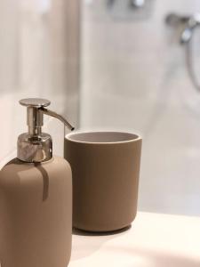 a soap dispenser and a cup on a counter at Fewo Kuferzeile Gmunden seenähe in Gmunden