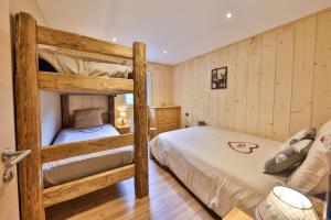 2 literas en una habitación con paredes de madera en Le Refuge du Bûcheron en Mittlach