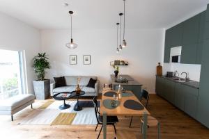 cocina y sala de estar con mesa y sofá en Stilvolle Wohnung mit ruhig gelegenem Balkon, en Viena