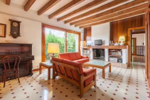 a living room with a piano and a chair at Can Sebrià in Gélida