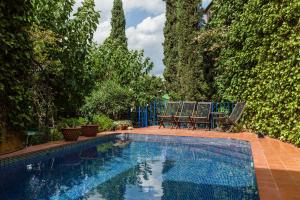 una piscina en un patio con sillas y árboles en Can Sebrià, en Gélida