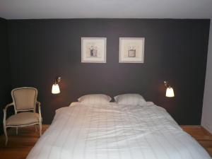 a bedroom with a large white bed and two chairs at Gite des Comagnes in Limbourg